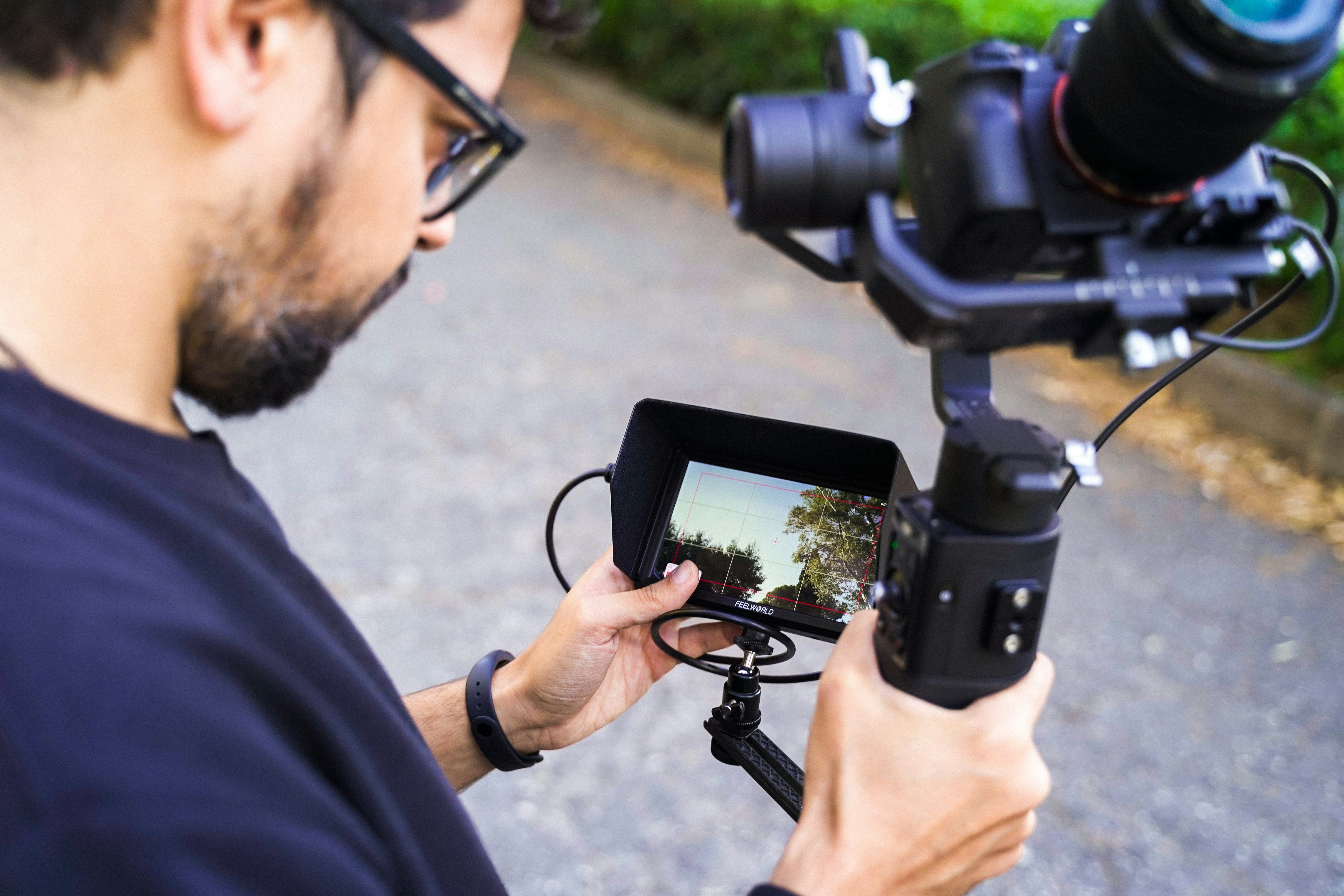 man in blue shirt holding black dslr camera